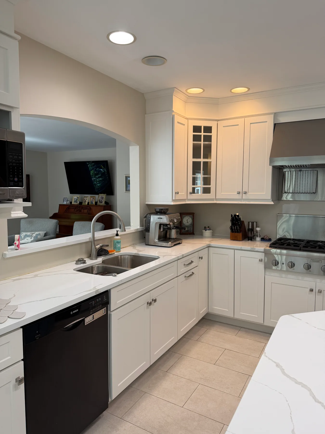 Kitchen sink and corner cabinetry with glass-front upper doors