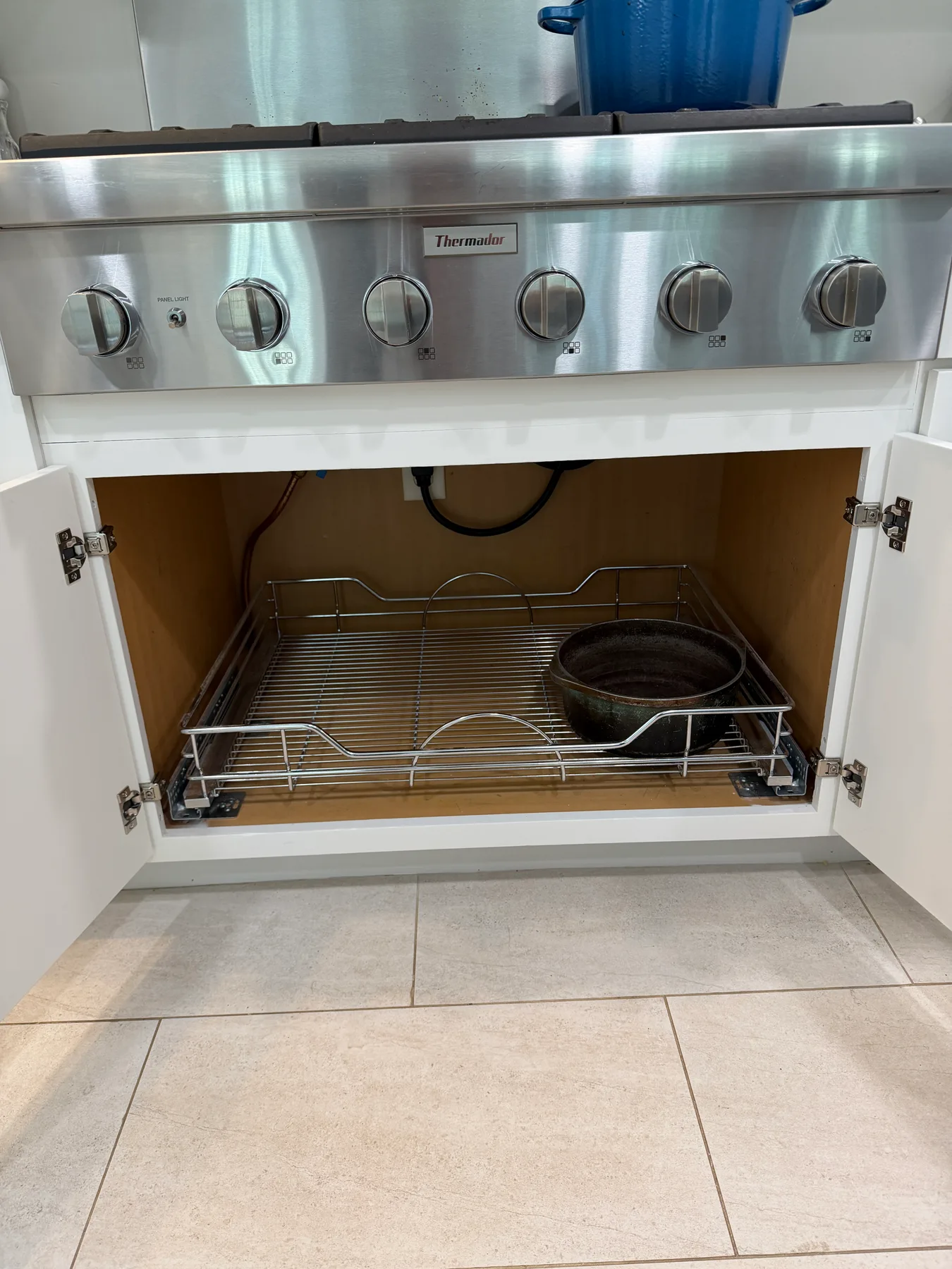 Pull-out wire storage rack in the cabinet beneath the range
